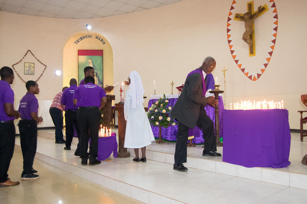 Parishioners light and place candles at the Altar