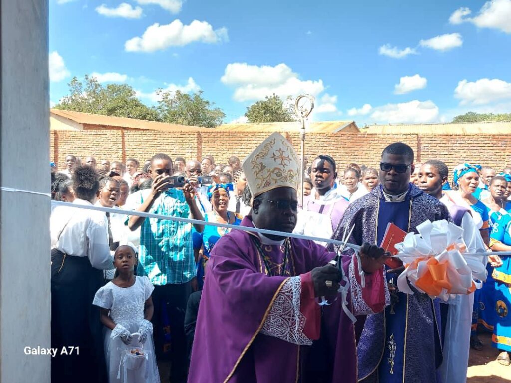 Archbishop George Desmond Tambala cuts the ribbon to the new house