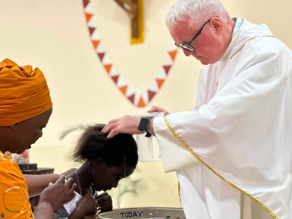 fr martin mulholland baptising at st kizito first holy communion